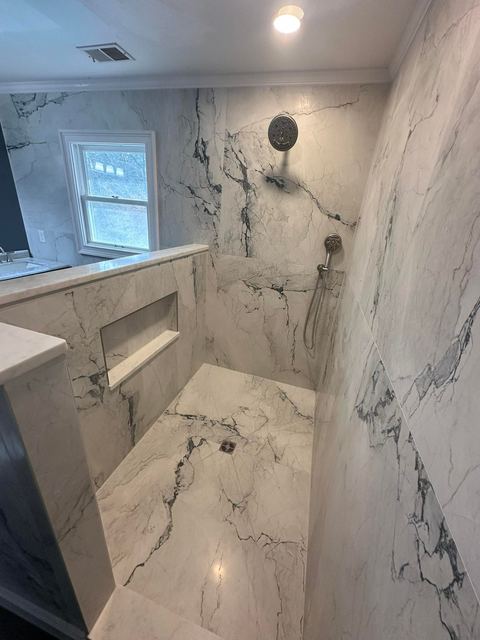 Bold-vein marble-look shower with a ledge niche