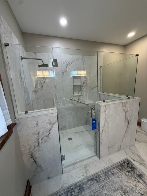 Marble-look shower with glass and a half wall